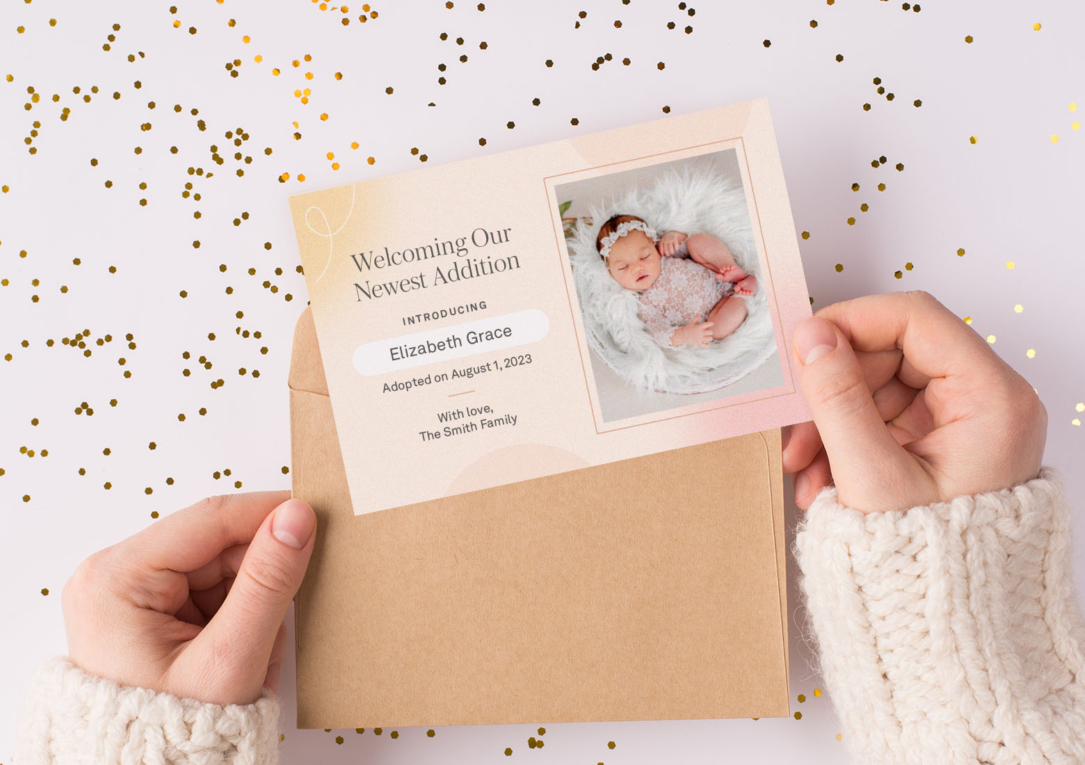 Hands holding an adoption announcement card that says welcoming our newest addition