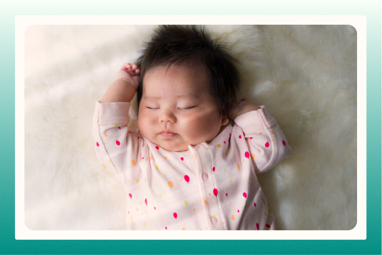 close up of infant in onesie sleeping on white fluffy blanket