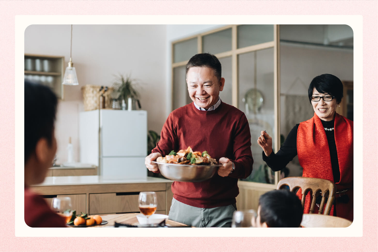 man brings bowl of food to table for family dinner