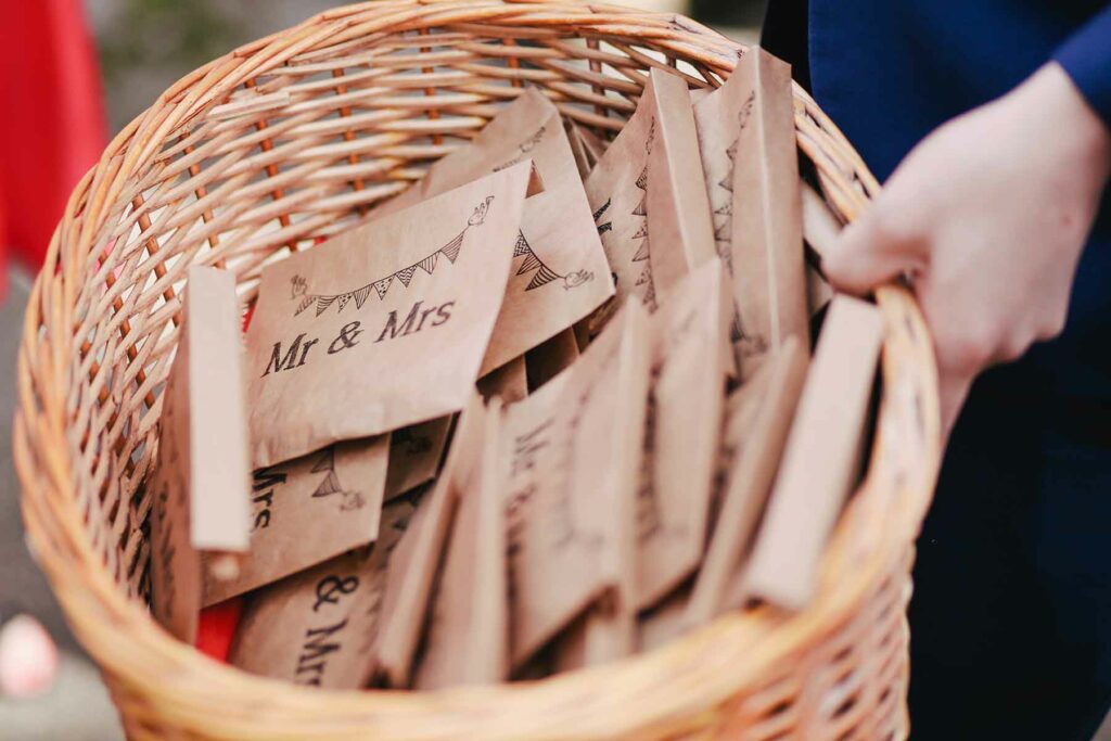 Person holding woven basket filled with kraft paper party favor bags
